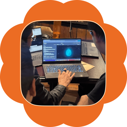 Community members at a laptop building an interactive 3D scene, a glowing 3D object on screen
